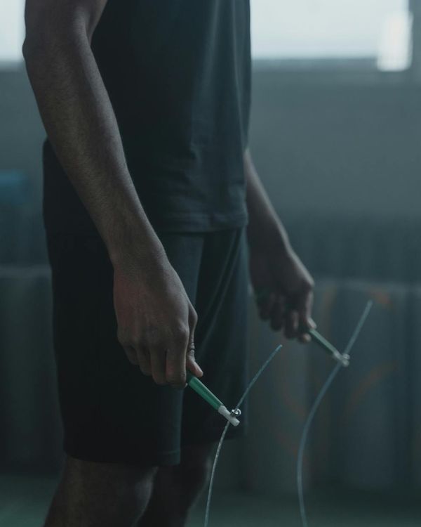 Man performing a strength exercise in a modern gym with cyan light.